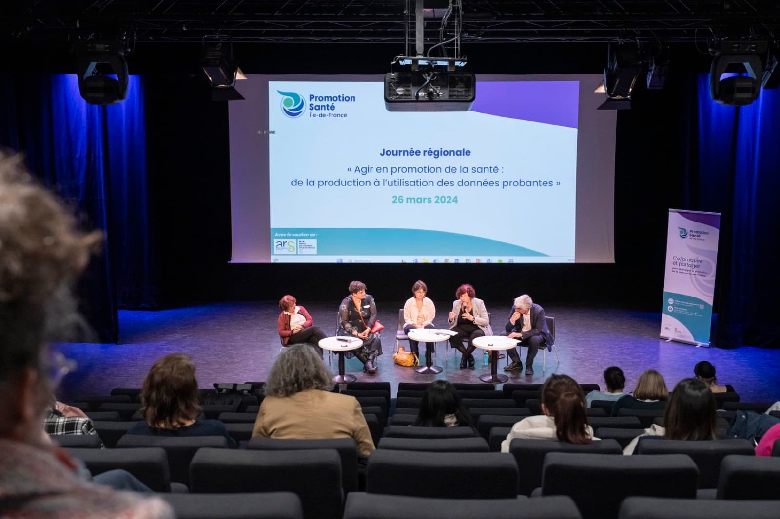 Table ronde sur scène devant un public lors d'une conférence