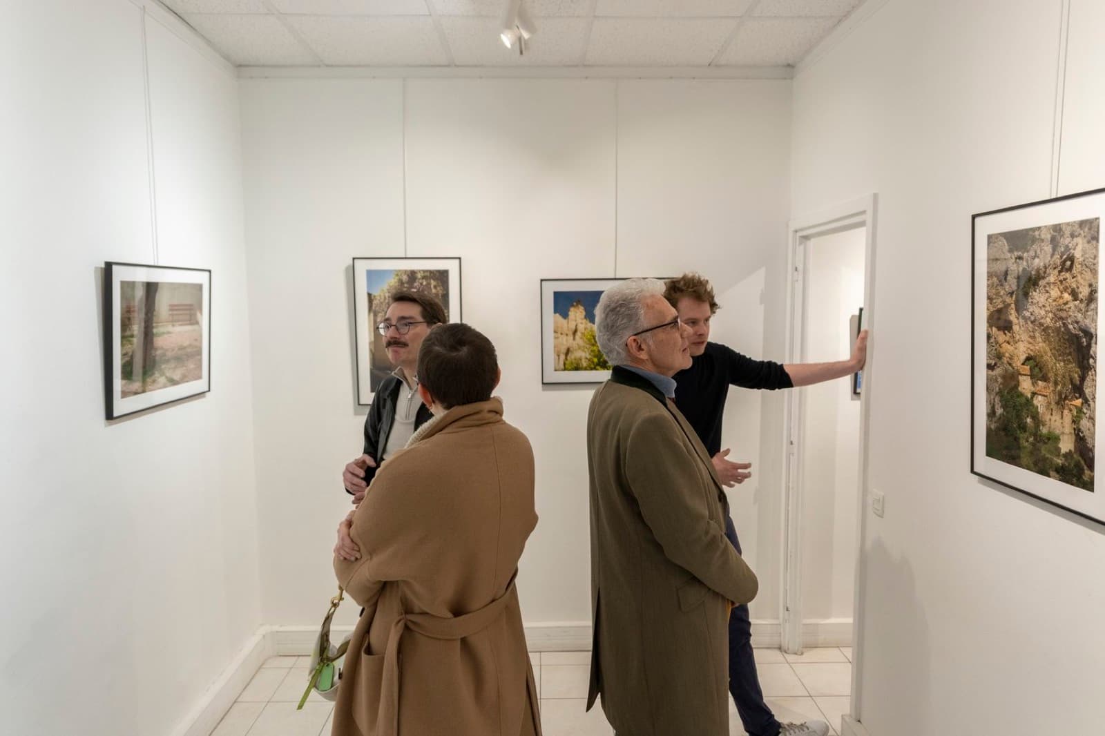 Invités échangeant devant les œuvres pendant un vernissage